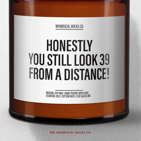 Funny 40th birthday candle with label βHonestly, You Still Look 39 From a Distanceβ in 9oz amber jar; perfect milestone birthday gag gift.