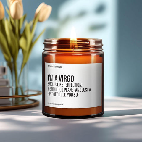 Close-up of a 9oz amber glass jar candle with black metal lid, white label reading “I’m a Virgo – Smells Like Perfection, Meticulous Plans, and Just a Hint of ‘I Told You So’” in bold black text, styled on a neutral background with warm lighting, perfect for humorous zodiac gifting.