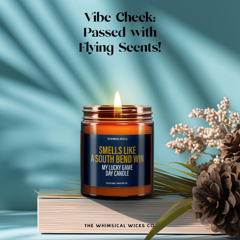 Lit amber glass candle with the same label surrounded by dried florals and pinecones, radiating warmth and cozy fall vibes—perfect for tailgating or gifting your favorite Notre Dame fan.