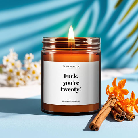 Image of a candle labeled “Fuck, You're Twenty” in a brown glass jar, styled in a cozy setting with birthday-themed props. A funny birthday candle gift idea for 20-year-olds. Perfect for celebrating turning twenty with attitude and humor.