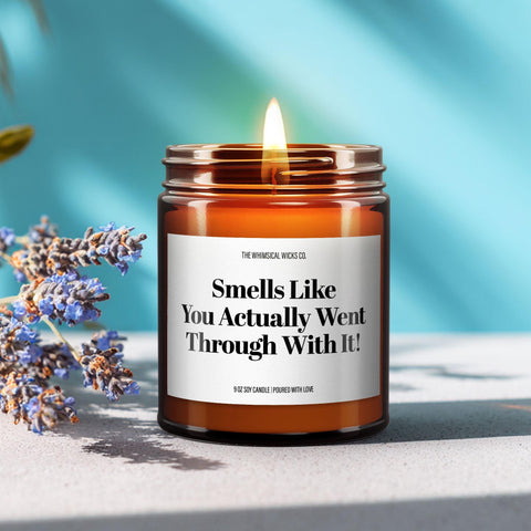 Close-up of a 9oz amber glass jar candle with black metal lid, white label reading “Smells Like You Actually Went Through With It!” in bold black text, styled on a neutral background with warm lighting, perfect for funny newlywed gifting.