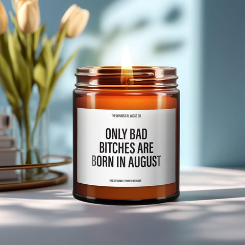 Close-up of a 9oz amber glass jar candle with black metal lid, white label reading “Only Bad Bitches Are Born in August” in bold black text, styled on a neutral background with warm lighting, perfect for cheeky August birthday gifting.