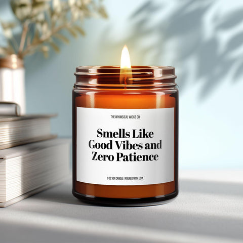 Close-up of a 9oz amber glass jar candle with black metal lid, white label reading “Smells Like Good Vibes and Zero Patience” in bold black text, styled on a neutral background with warm lighting, perfect for sassy manifestation gifting.