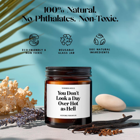 Amber jar candle labeled “You Don’t Look a Day Over Hot as Hell” with text highlighting eco friendly & non toxic, reusable glass jar, 100% natural ingredients.